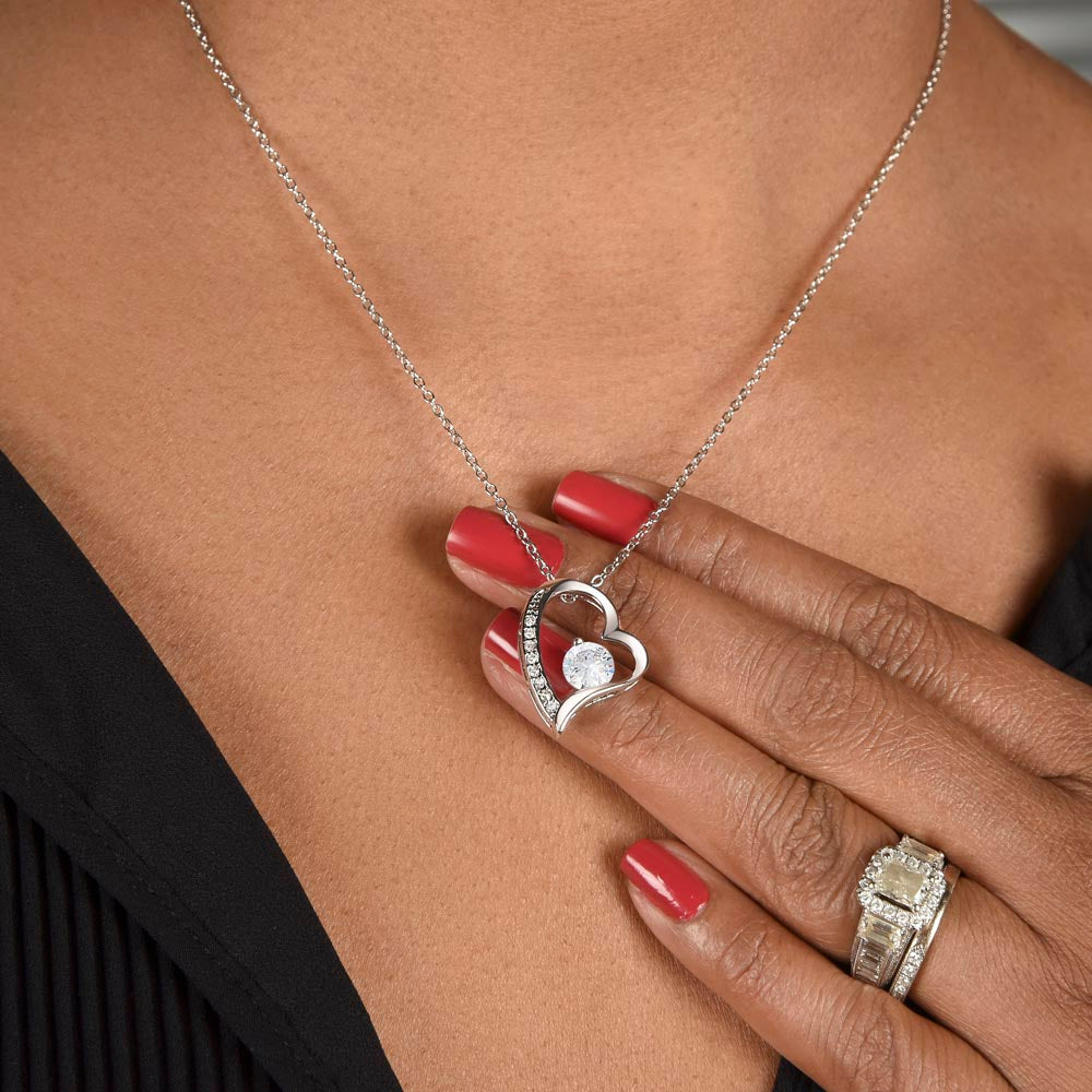 Hand with a ring holding the Forever Love heart pendant at the neck (Being Your Dad charcoal card set)