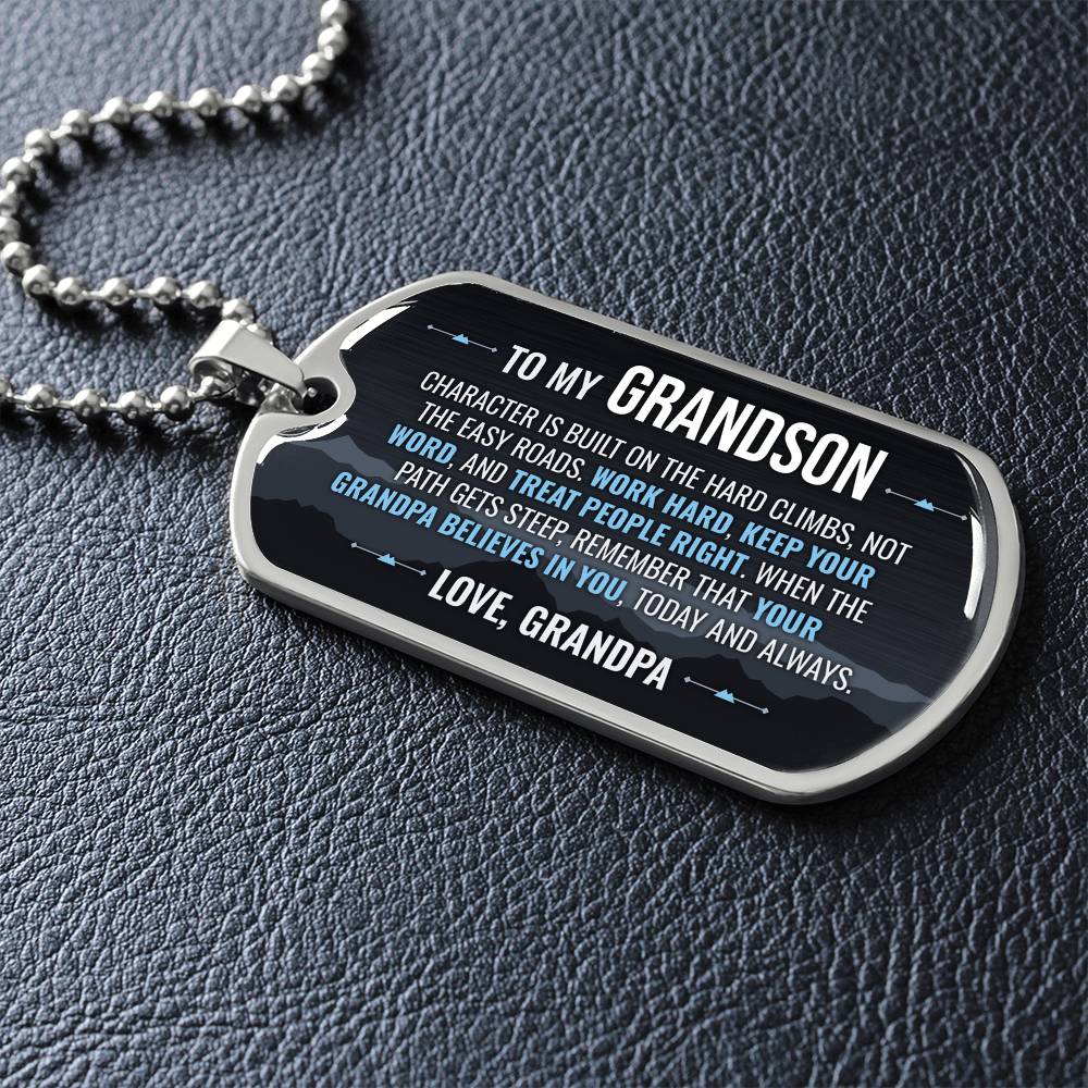 To My Grandson Necklace from Grandpa – silver dog tag necklace lying flat on black leather so the sideways message reads clearly