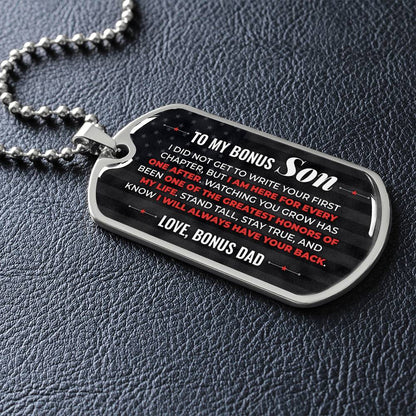To My Bonus Son Necklace from Stepdad – silver dog tag necklace lying flat on black leather so the sideways message reads clearly