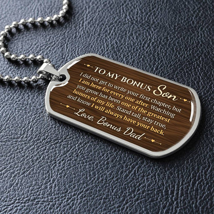 To My Bonus Son Necklace from Stepdad – silver dog tag necklace lying flat on black leather so the sideways message reads clearly