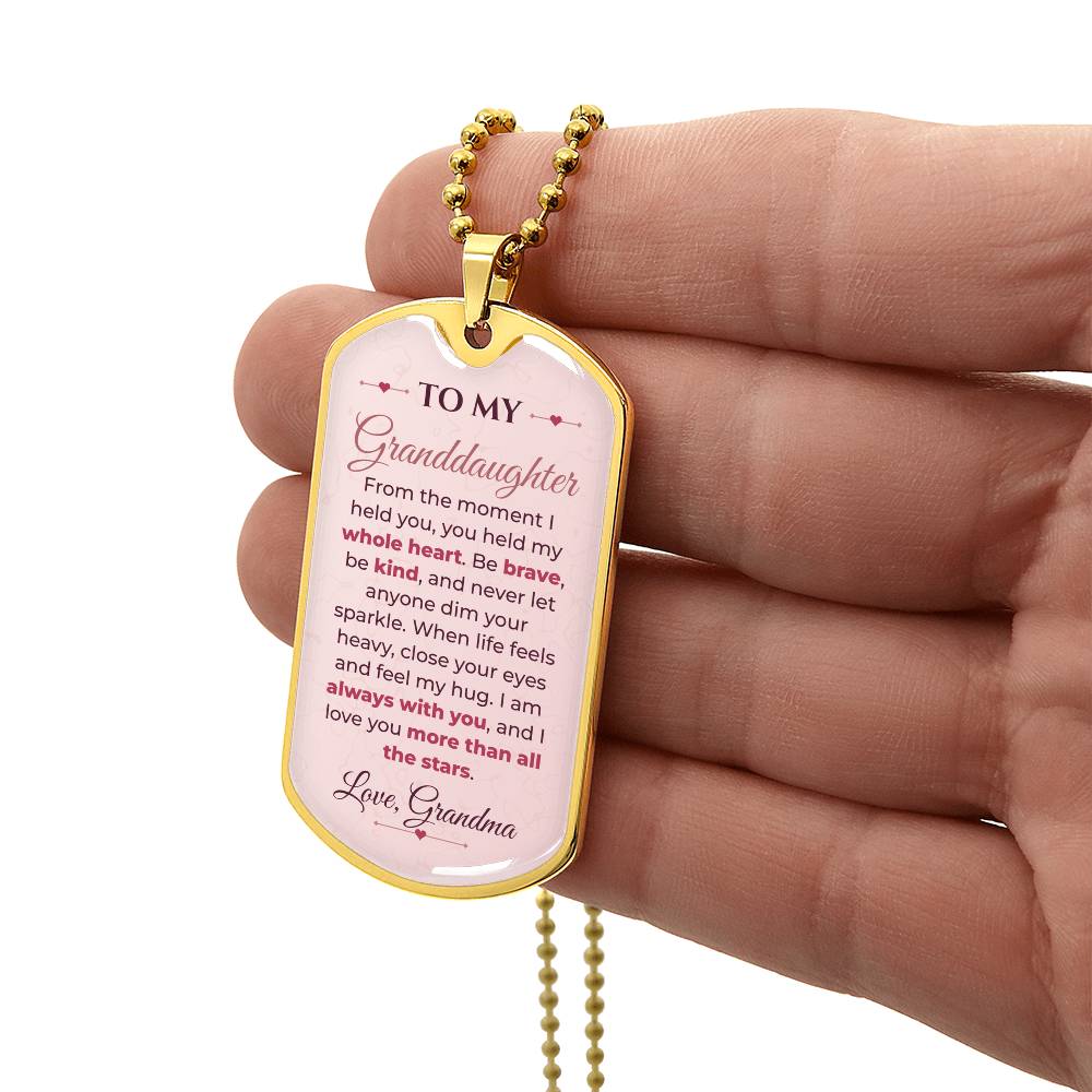 To My Granddaughter Necklace from Grandma – gold dog tag held in hand to show size