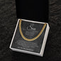 Gold-finish Cuban link chain on the charcoal script To My Son card in a white gift box on a dark textured surface