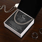 Charcoal To My Son script card and Cuban link chain in gift box on dark wood table beside rings and a dog tag