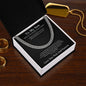 To My Son Cuban link chain on black card in gift box on wood table next to a gold dog tag and gold rings