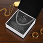High-angle view of charcoal script To My Son chain box on wood table with a gold dog tag and gold rings