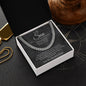 Charcoal script To My Son card in open box on dark compass surface with gold dog tag and wooden decor behind