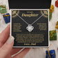 Hand holding the black and gold To My Daughter card from Dad and Love Knot necklace box among wrapped Christmas gifts