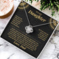 Open black gift box with the black and gold To My Daughter card from Dad and Love Knot necklace, angled view