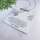 White To My Daughter card from Mom with the Love Knot necklace beside a pine sprig