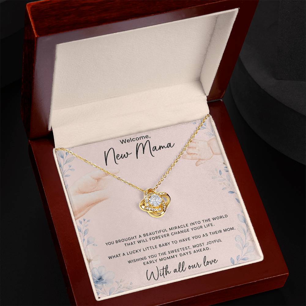 Yellow gold Love Knot necklace spotlighted in luxury LED gift box with oezzo message card