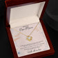 Yellow gold Love Knot necklace spotlighted in luxury LED gift box with oezzo message card