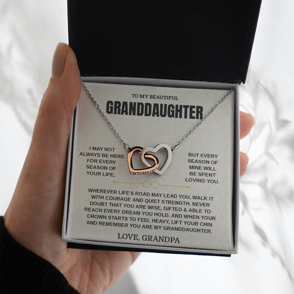 Hand holding the Interlocking Hearts necklace on the cream Love, Grandpa card in a black gift box