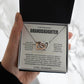 Hand holding the Interlocking Hearts necklace on the cream Love, Grandpa card in a black gift box