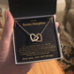 Open gift box with the black and gold To My Bonus Daughter card and Interlocking Hearts necklace held up indoors