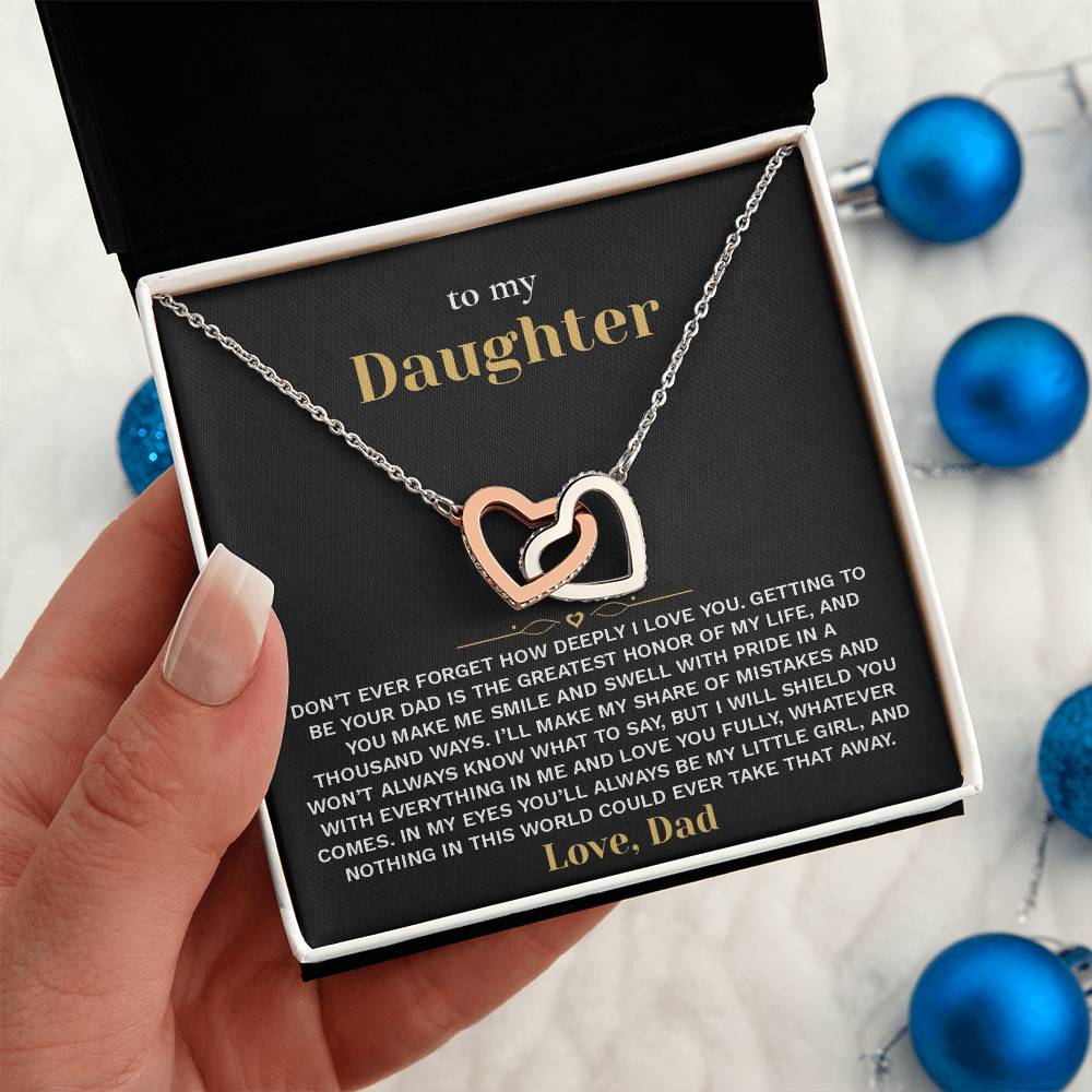 Hand holding the black and gold To My Daughter card from Dad gift box beside blue Christmas ornaments