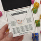 Hand holding the Love, Grandpa card and linked hearts necklace box among wrapped Christmas gifts
