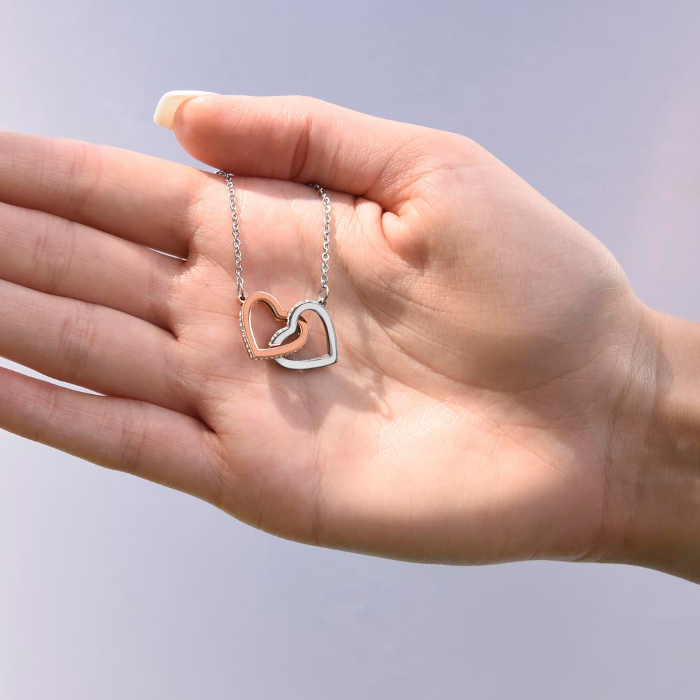 Interlocking Hearts necklace from Grandpa resting in an open palm