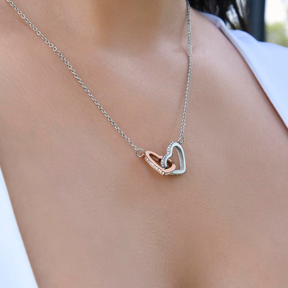 Linked hearts pendant worn at the neckline, side view