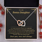 Black and gold To My Bonus Daughter card with the Interlocking Hearts necklace in a gift box beside red berries