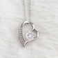 Close-up of the Forever Love heart pendant with round cubic zirconia on white fur (Being Your Dad charcoal card set)