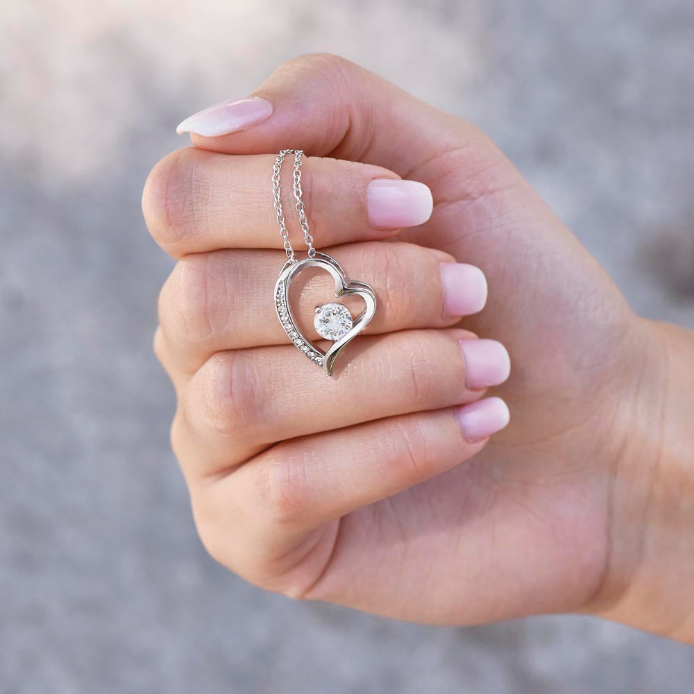 Hand holding the Forever Love heart pendant up to show its sparkle (Love, Grandma granddaughter set)