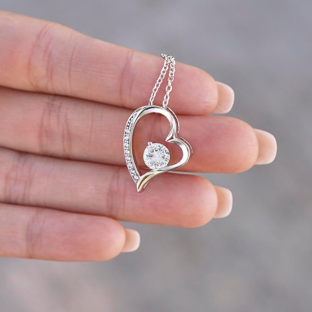 Fingertips holding the Forever Love heart pendant, close-up (Being Your Dad charcoal card set)