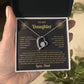 Hand holding an open black gift box with the black and gold To My Daughter card from Dad and heart pendant