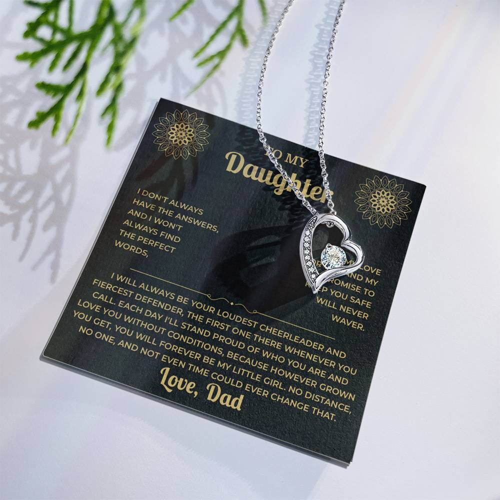 Black and gold To My Daughter card from Dad with heart necklace laid flat beside a pine sprig