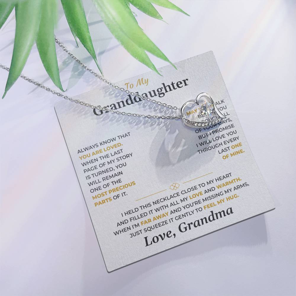 Forever Love heart necklace on the soft gray To My Granddaughter card from Grandma with green leaves, white background