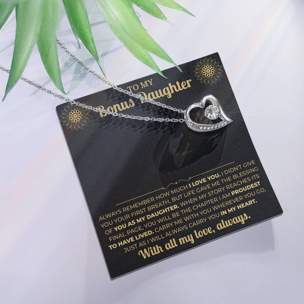 Forever Love heart necklace on the black and gold To My Bonus Daughter card with green leaves, white background