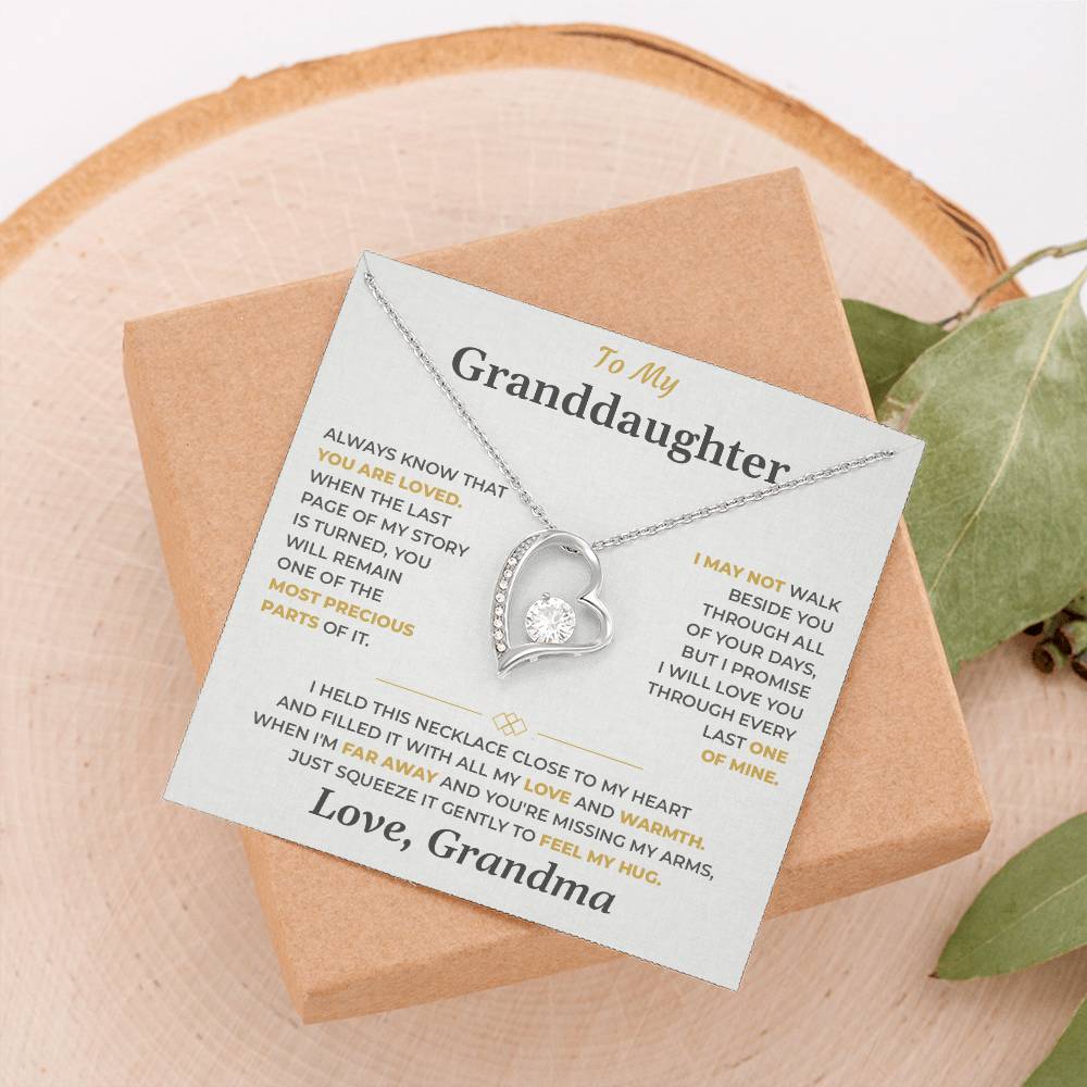 Soft gray To My Granddaughter card from Grandma with Forever Love necklace on a wood slice beside greenery