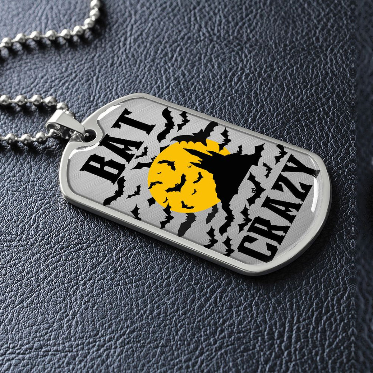 Silver Bat Crazy bat and moon dog tag lying on black leather