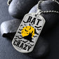 Silver Bat Crazy bat and moon dog tag necklace propped on dark river rocks