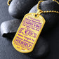 Gold-finish I Love You Daughter dog tag propped on dark river rocks