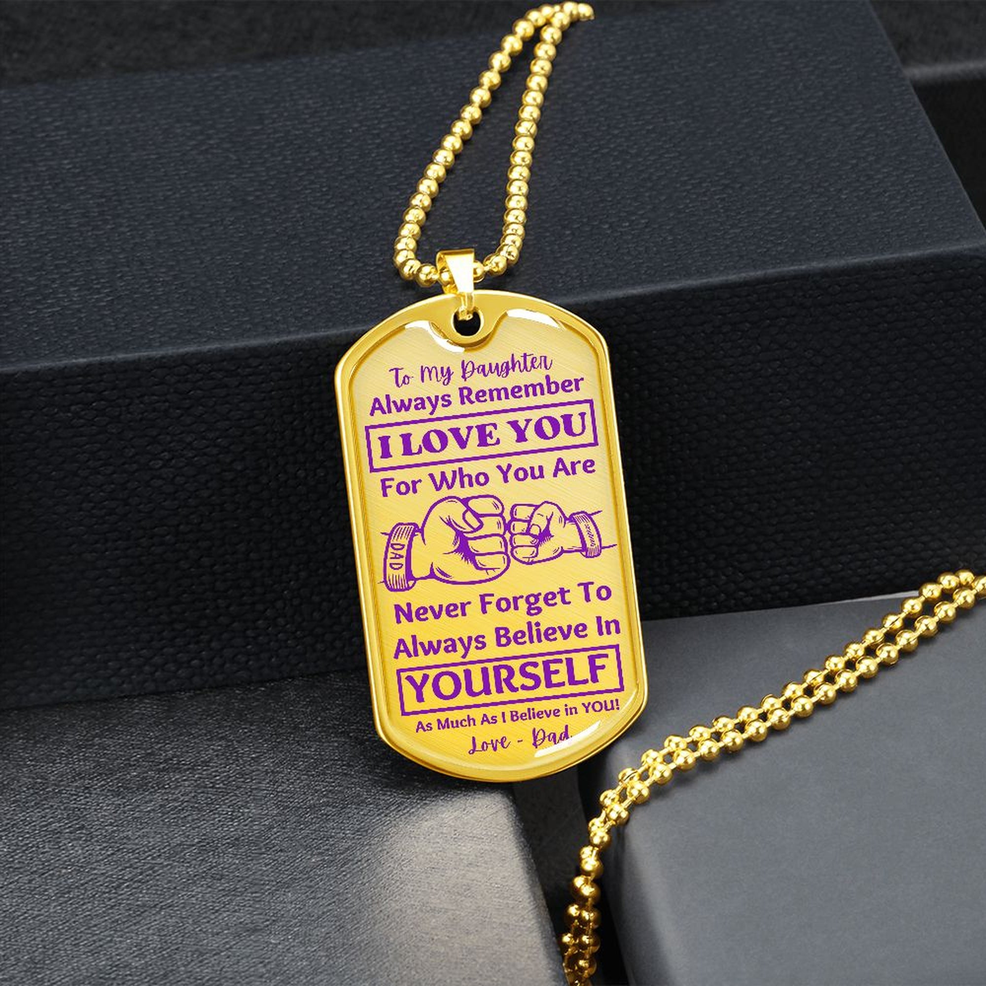 Gold-finish I Love You Daughter dog tag hanging over a black gift box