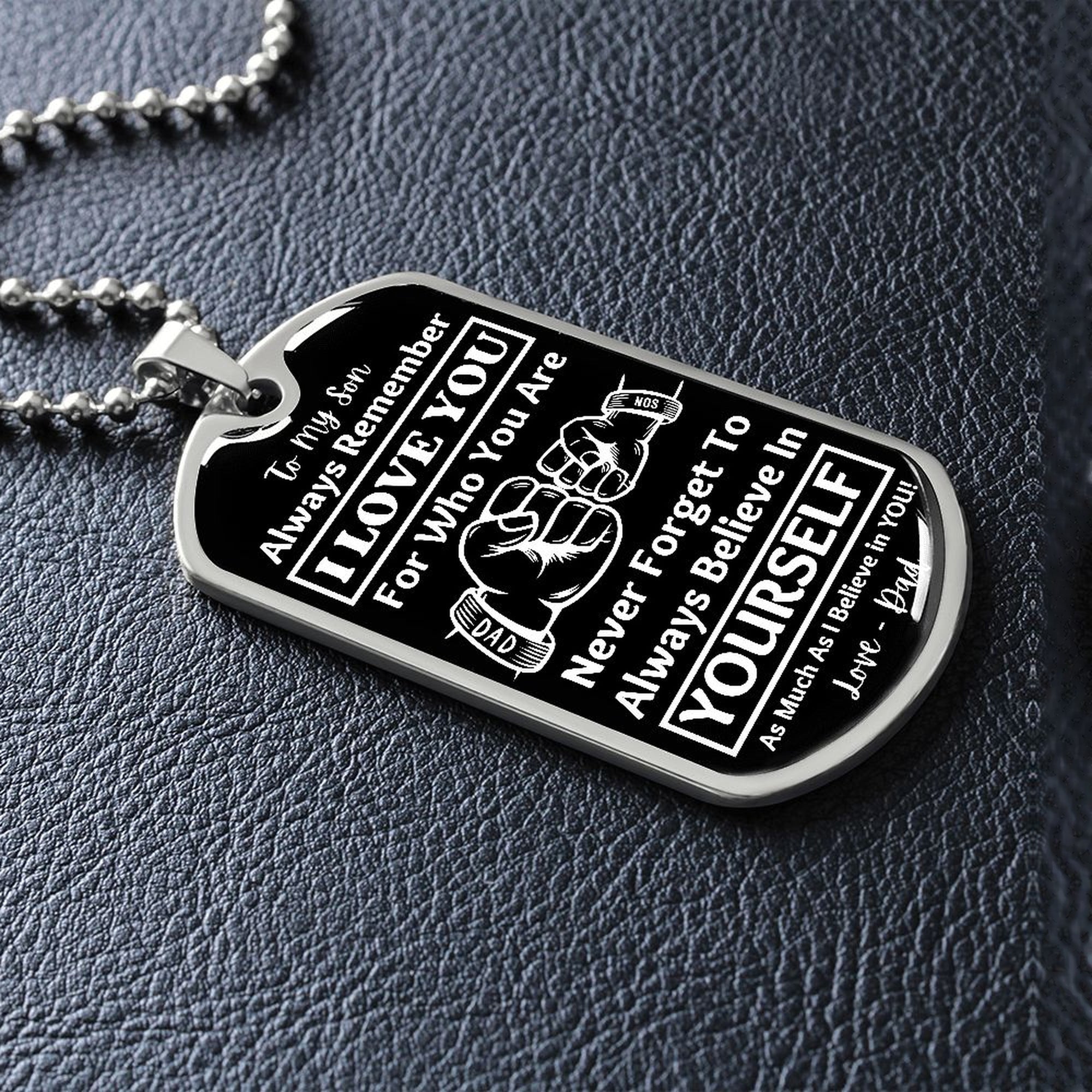 Silver Believe in Yourself son dog tag lying on black leather