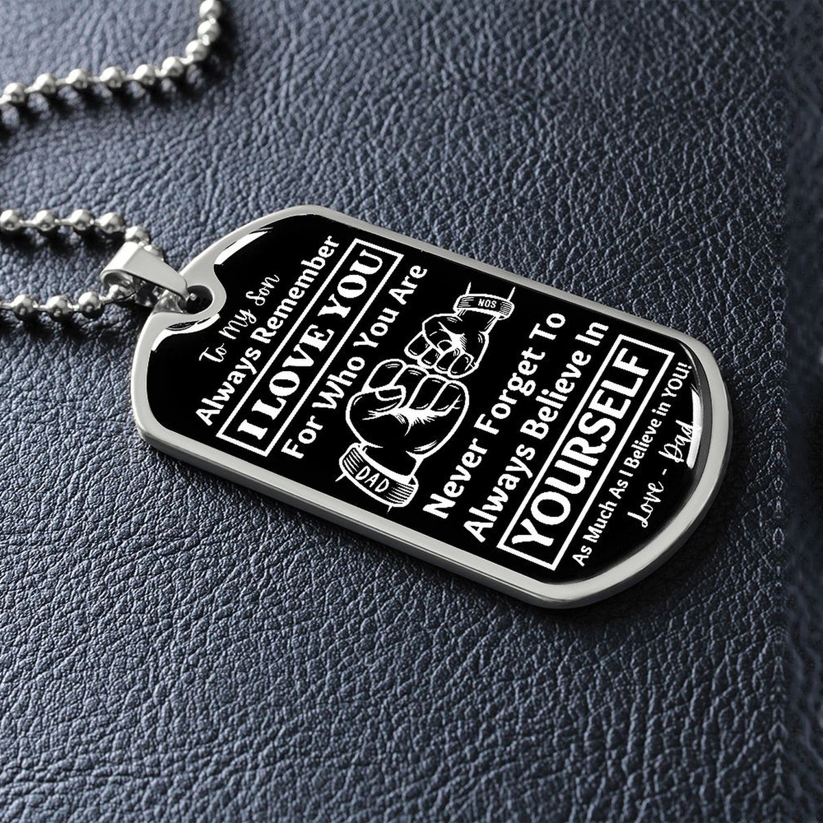 Silver Believe in Yourself son dog tag lying on black leather