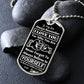 Silver Believe in Yourself son dog tag propped on dark river rocks
