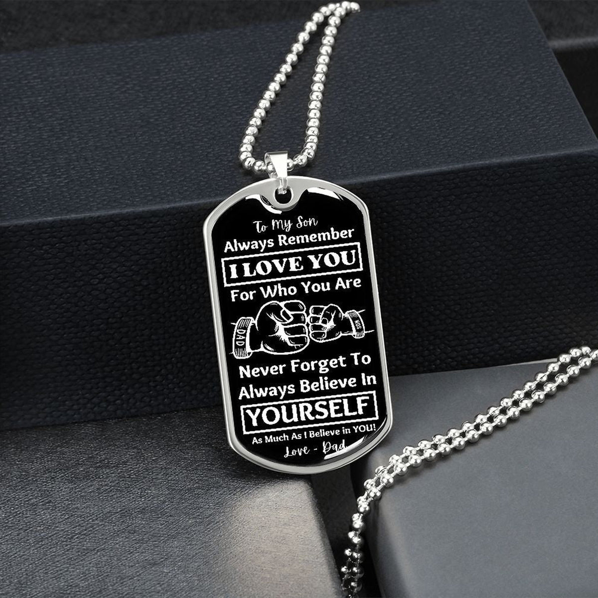 Silver Believe in Yourself son dog tag hanging over a black gift box