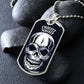 Silver Fright Night skull dog tag necklace propped on dark river rocks