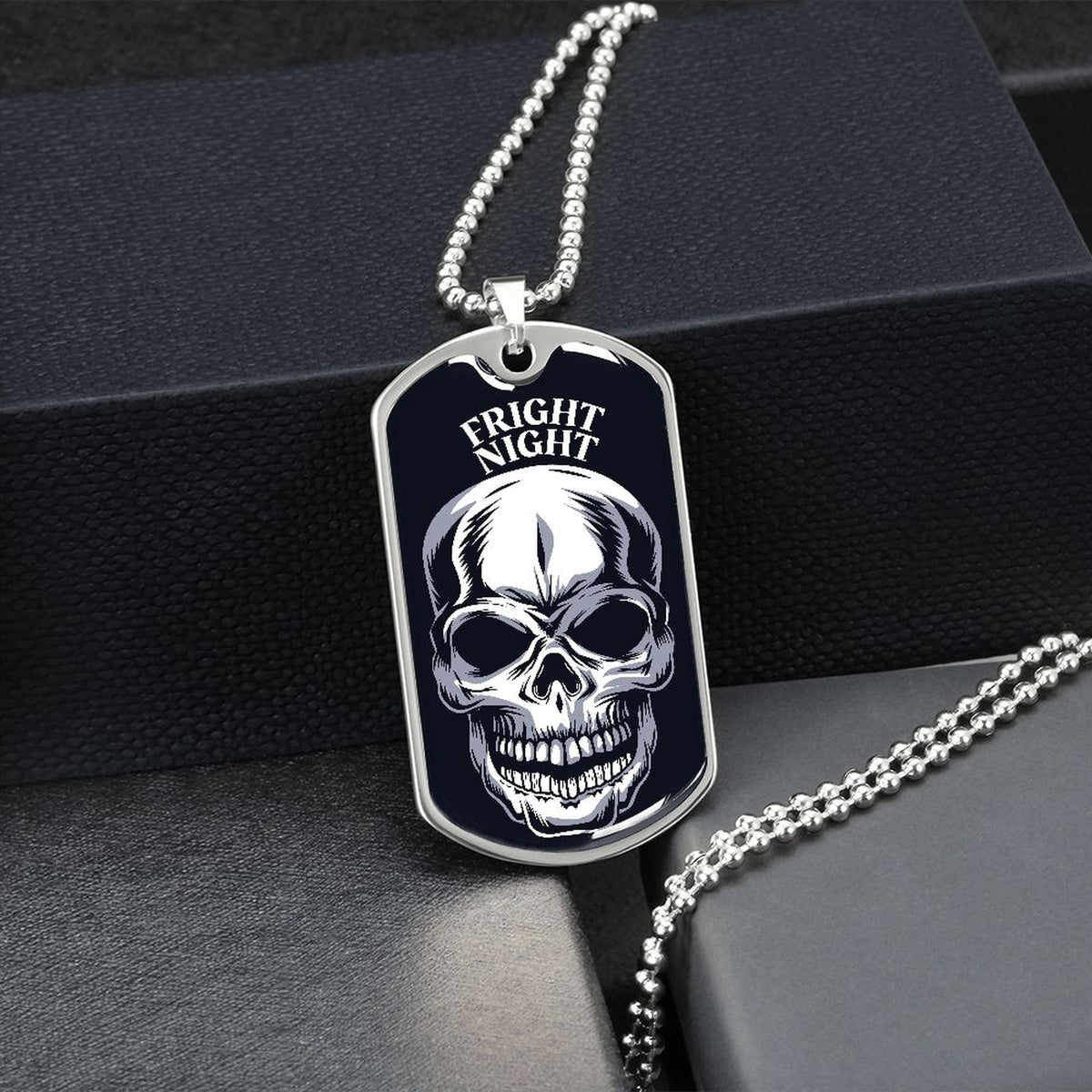 Silver Fright Night skull dog tag hanging over a black gift box