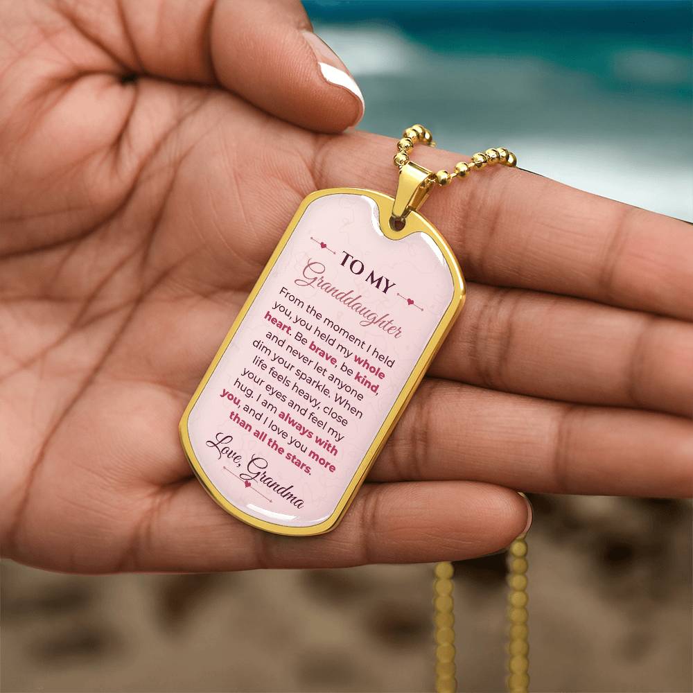 To My Granddaughter Necklace from Grandma – gold dog tag held in hand to show size