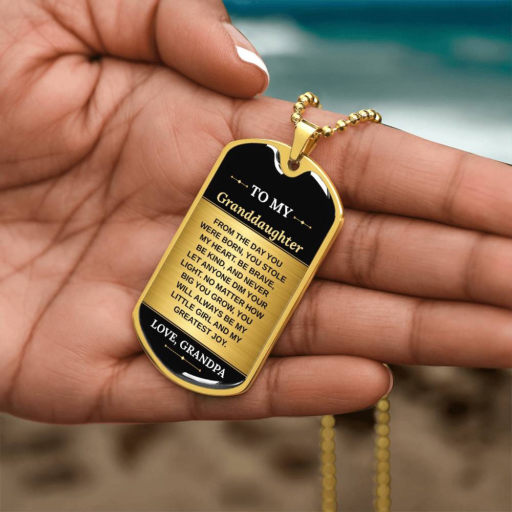 To My Granddaughter Necklace from Grandpa – gold dog tag held in hand to show size