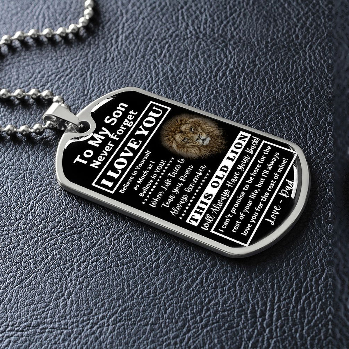 Silver Old Lion son dog tag lying on black leather