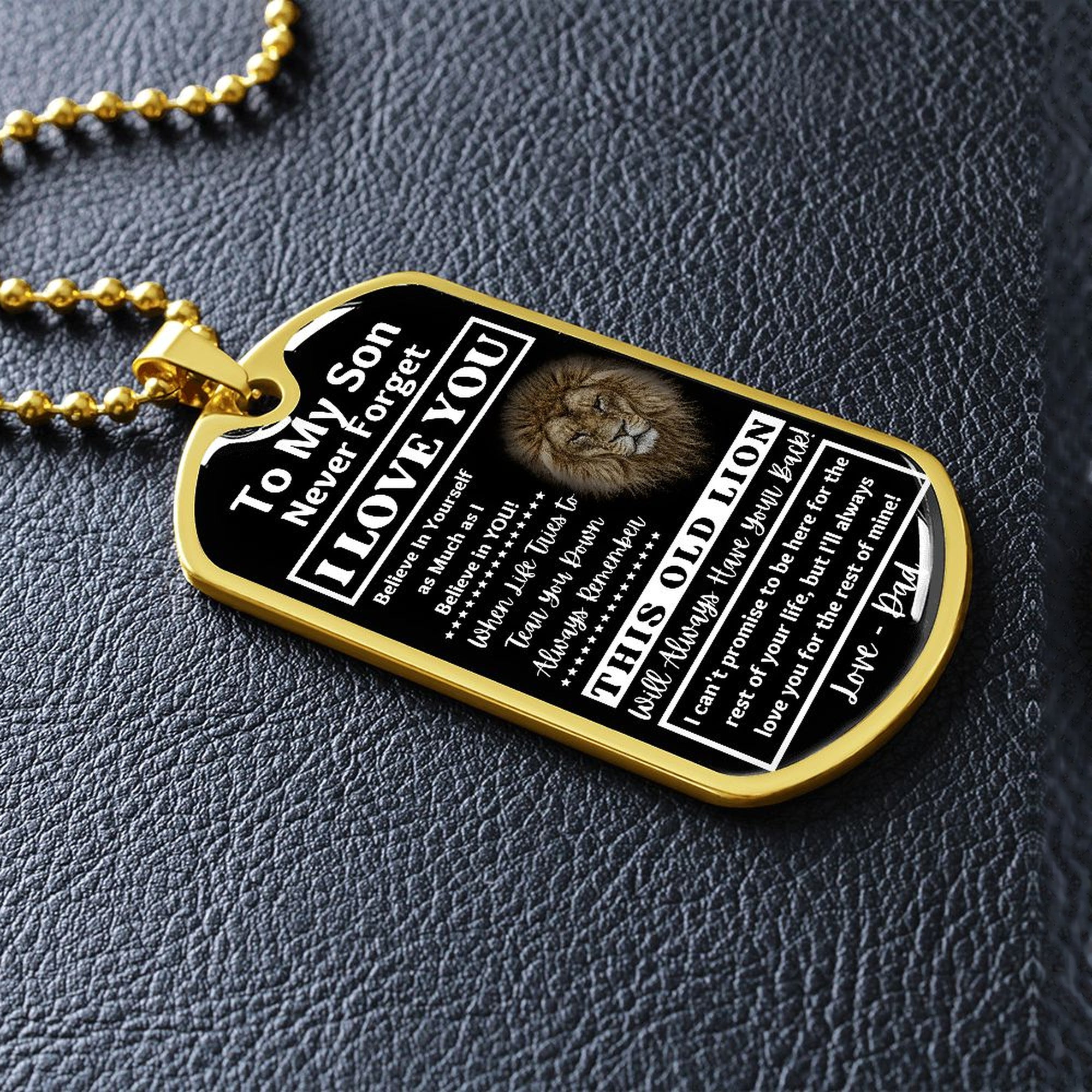 Gold-finish Old Lion son dog tag lying on black leather