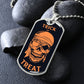 Silver Trick or Treat pirate skull dog tag necklace propped on dark river rocks
