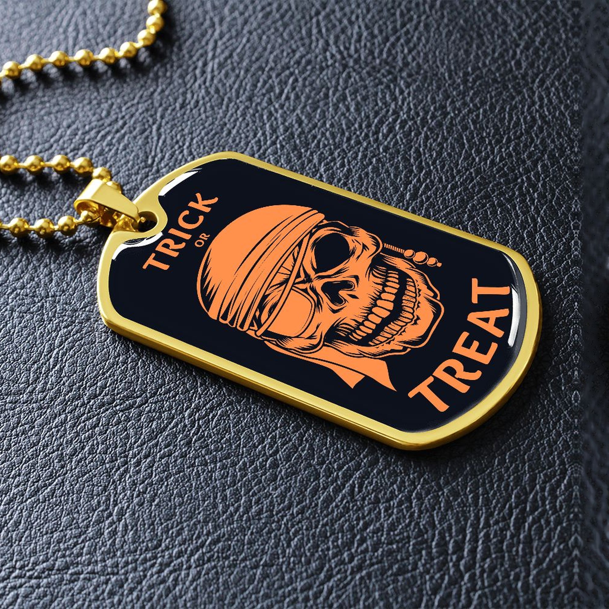 Gold-finish Trick or Treat pirate skull dog tag lying on black leather