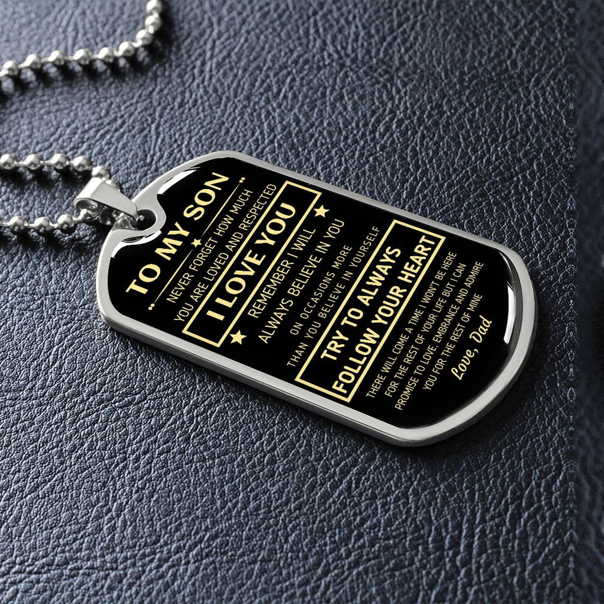 Silver To My Son dog tag lying on black leather